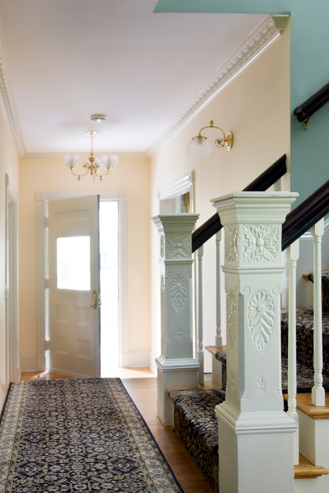 Esempio di un corridoio tradizionale di medie dimensioni con pareti beige, parquet chiaro, una porta singola e una porta bianca