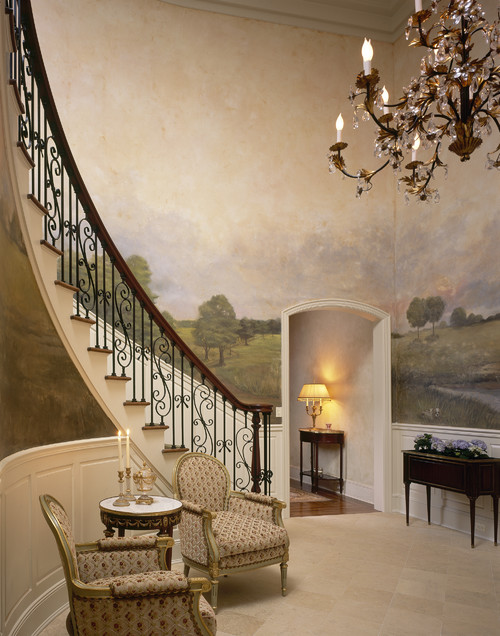 Curved traditional staircase with huge landscape mural on the wall and iron railing