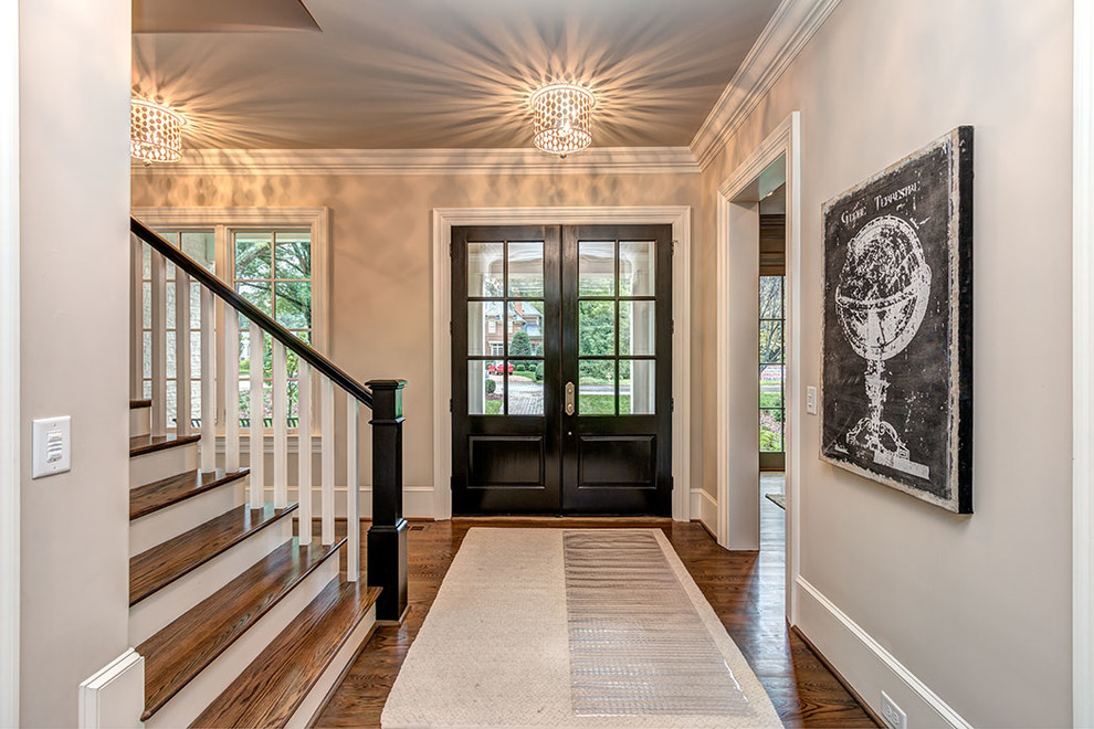 Klassisches Foyer mit grauer Wandfarbe, braunem Holzboden, Doppeltür und Haustür aus Glas in Charlotte