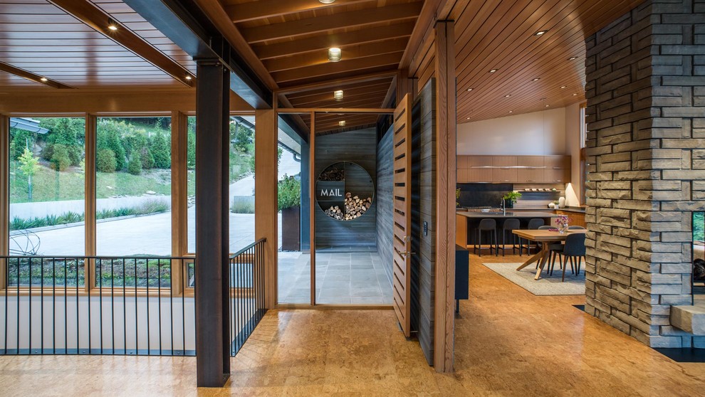 Idée de décoration pour un hall d'entrée design de taille moyenne avec un mur gris, parquet en bambou, une porte simple, une porte en bois brun et un sol beige.