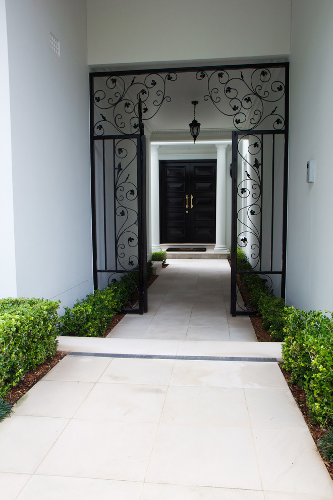 На фото: маленькое фойе в современном стиле с серыми стенами, полом из известняка, двустворчатой входной дверью и черной входной дверью для на участке и в саду