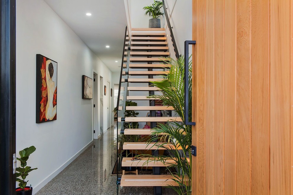 Diseño de escalera recta minimalista pequeña con escalones de madera y barandilla de vidrio