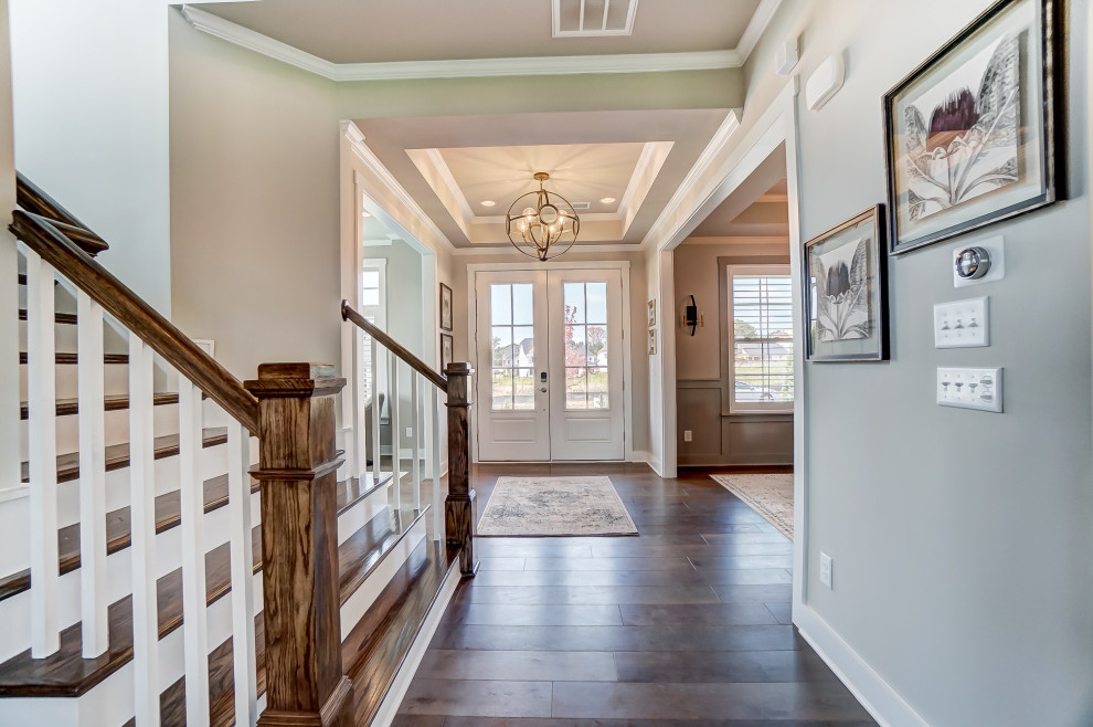 Mid-sized transitional dark wood floor and tray ceiling entryway photo in Charlotte with beige walls and a white front door