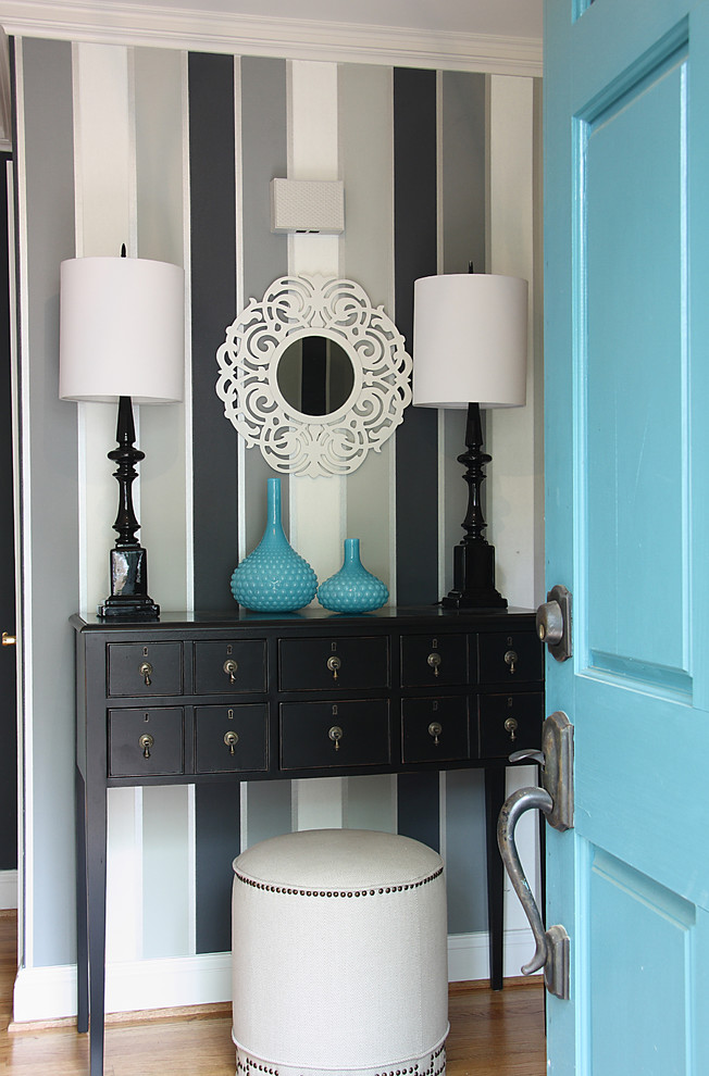 Diseño de distribuidor clásico renovado con paredes multicolor, suelo de madera clara, puerta simple y puerta azul