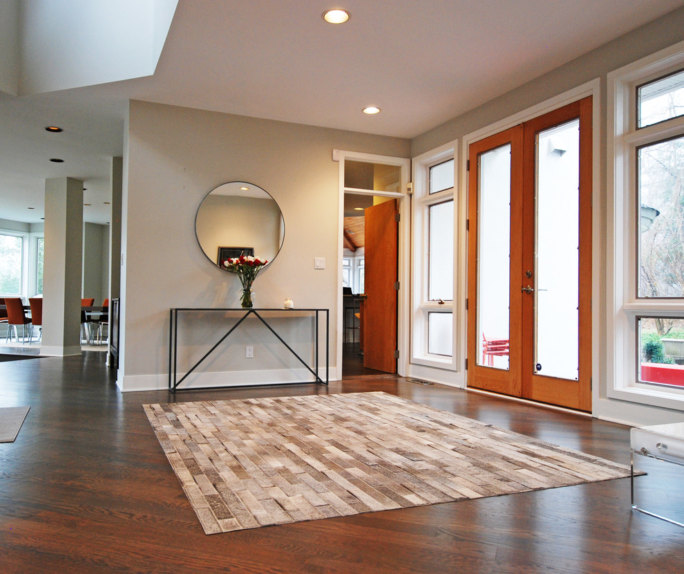 Entryway - large contemporary medium tone wood floor entryway idea in DC Metro with beige walls and a glass front door