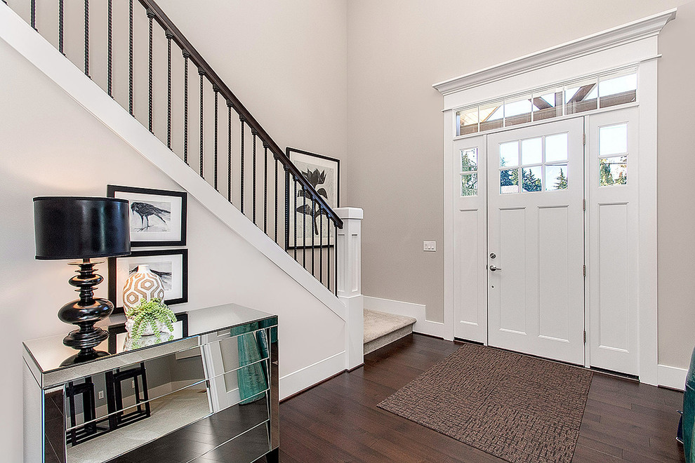 Example of a large classic dark wood floor entryway design in Seattle with gray walls and a white front door