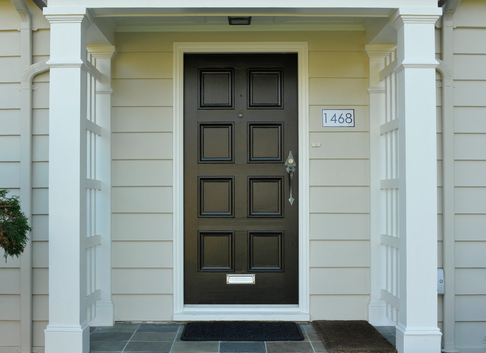 Imagen de puerta principal tradicional pequeña con paredes beige, suelo de pizarra, puerta simple, puerta negra y suelo gris