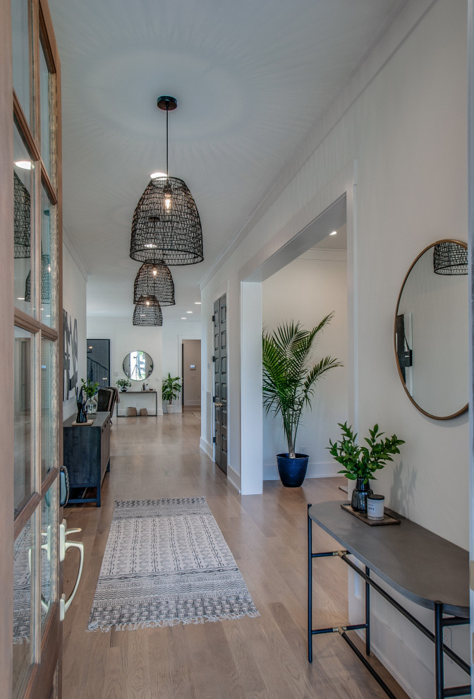 Large contemporary hallway in Nashville with white walls, light hardwood flooring, a single front door, a brown front door and beige floors.