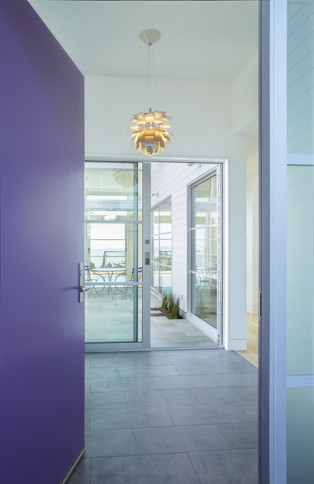 Exemple d'une entrée tendance avec une porte simple et une porte violette.