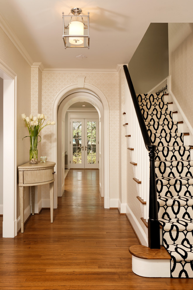 Immagine di un ingresso o corridoio chic con pareti beige e pavimento in legno massello medio