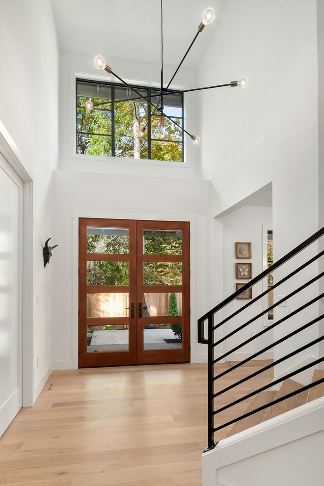 Diseño de puerta principal minimalista de tamaño medio con paredes blancas, suelo de madera clara, puerta doble, puerta de vidrio y suelo marrón