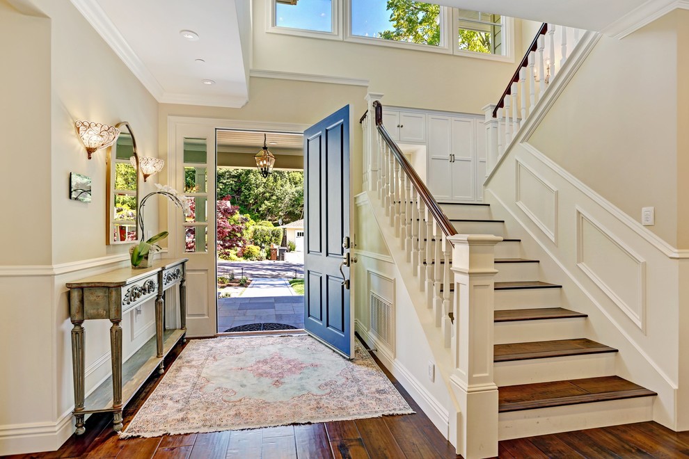 Idées déco pour une grande porte d'entrée classique avec un mur blanc, un sol en bois brun, une porte simple et une porte bleue.