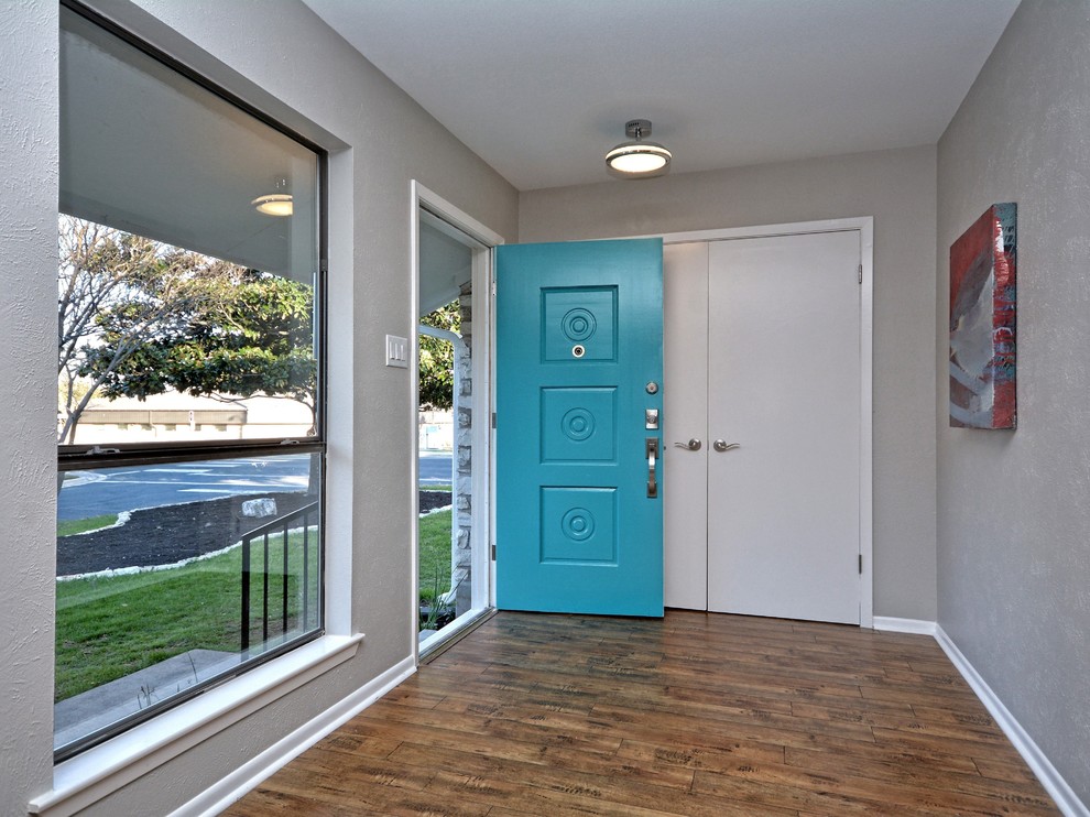 Mittelgroße Retro Haustür mit grauer Wandfarbe, braunem Holzboden, Einzeltür und blauer Haustür in Austin