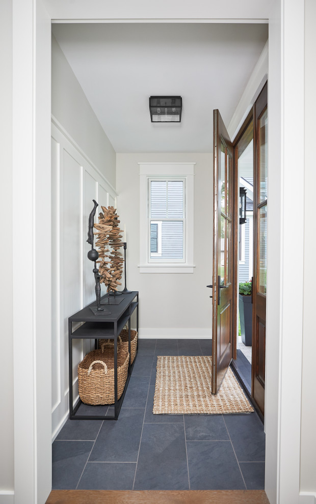 Ejemplo de distribuidor de estilo de casa de campo pequeño con paredes blancas, suelo de pizarra, puerta simple, puerta de madera en tonos medios y suelo azul