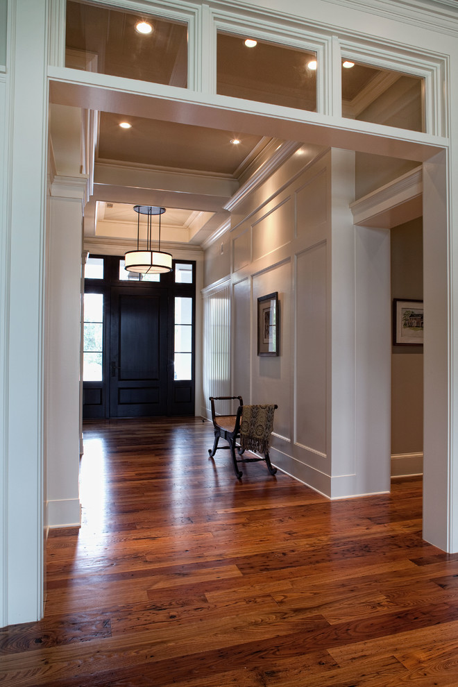 This is an example of a large traditional foyer in Charleston with white walls, medium hardwood flooring, a single front door and a black front door.