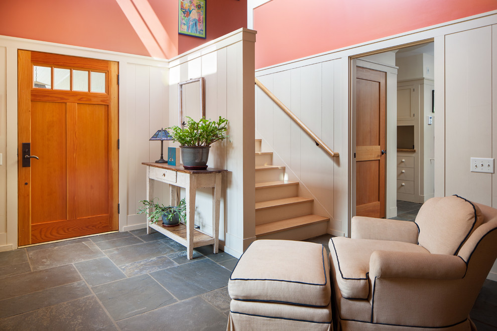 Réalisation d'un hall d'entrée craftsman avec un mur multicolore, une porte simple et une porte en bois brun.