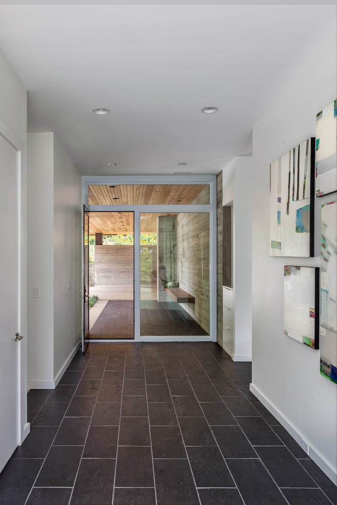 Example of a mid-sized trendy porcelain tile entryway design in Charleston with white walls and a dark wood front door