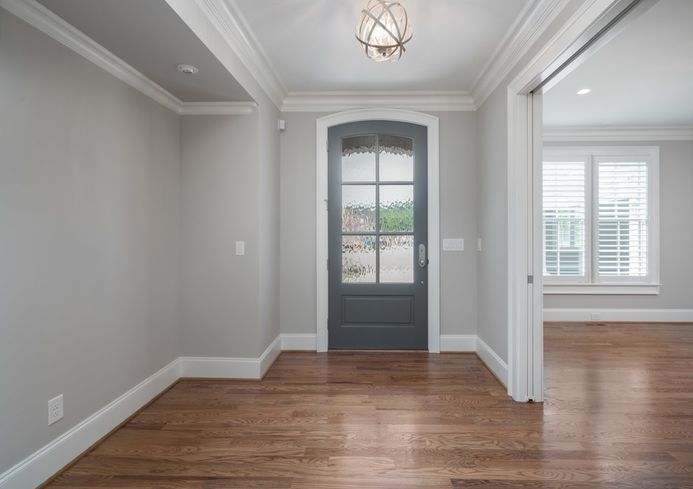 Idee per una porta d'ingresso classica di medie dimensioni con pareti grigie, pavimento in legno massello medio, una porta singola, una porta grigia e pavimento marrone