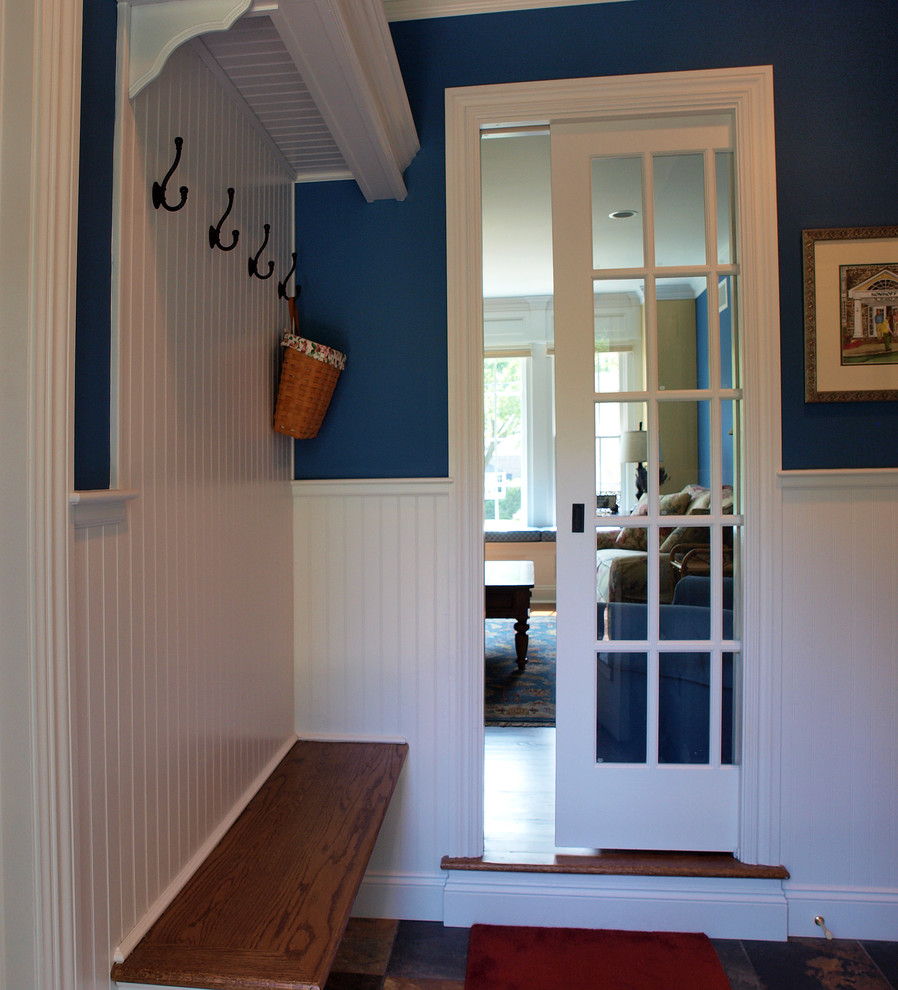 Imagen de vestíbulo posterior clásico con paredes azules y suelo de pizarra