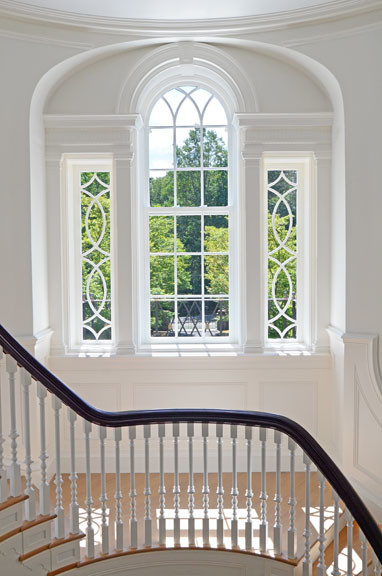 Geräumiges Klassisches Foyer mit weißer Wandfarbe, Kalkstein, Einzeltür, hellbrauner Holzhaustür und braunem Boden in New York