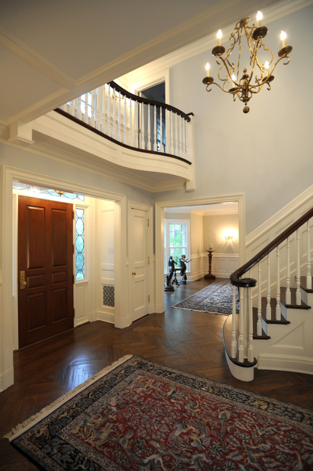 Foto di un corridoio classico di medie dimensioni con pareti blu, pavimento in legno massello medio, una porta singola e una porta in legno bruno