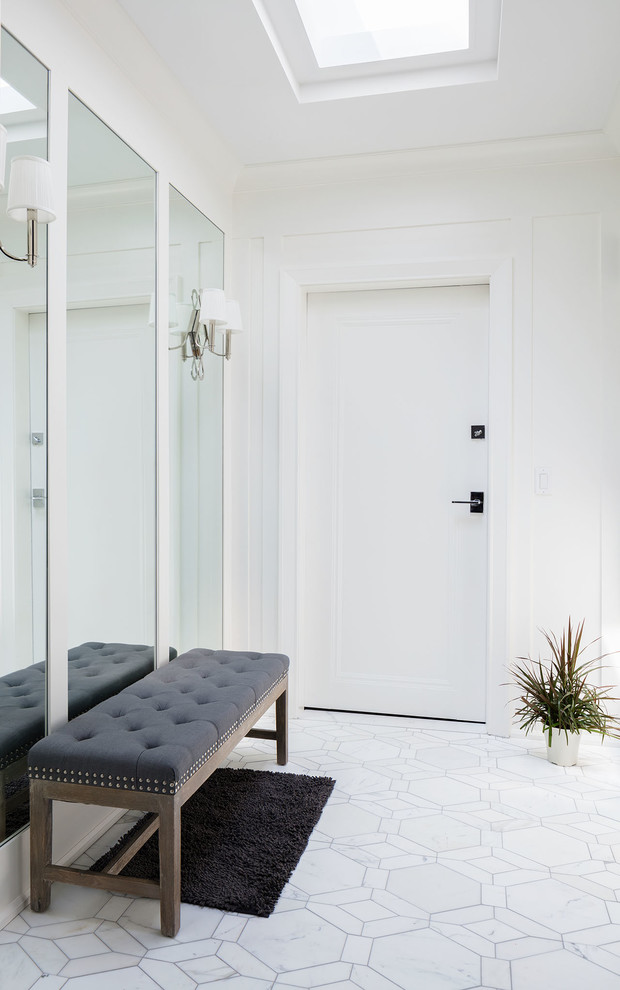 На фото: маленькая входная дверь в стиле неоклассика (современная классика) с белыми стенами, мраморным полом, одностворчатой входной дверью, черной входной дверью и белым полом для на участке и в саду с