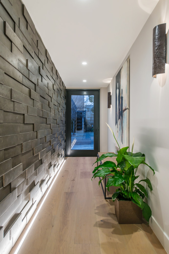 Modelo de hall actual de tamaño medio con paredes grises, suelo de madera clara, puerta simple, puerta de vidrio y suelo marrón
