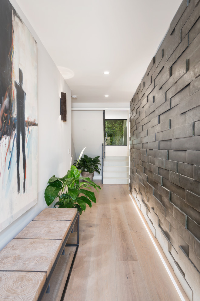 Inspiration pour une entrée design de taille moyenne avec un couloir, un mur gris, parquet clair, une porte simple, une porte en verre et un sol marron.