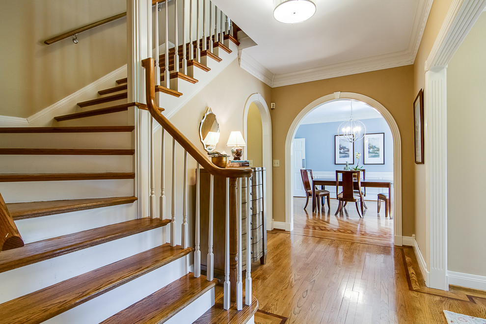 This is an example of a medium sized classic foyer in Louisville with beige walls, medium hardwood flooring, a single front door, a black front door and brown floors.