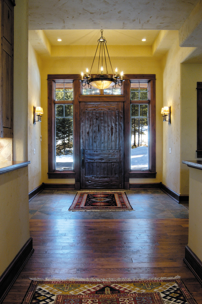 Bild på en rustik ingång och ytterdörr, med mellanmörkt trägolv, en enkeldörr, mörk trädörr och brunt golv