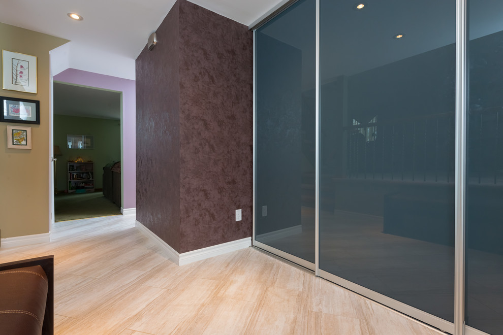 Imagen de distribuidor actual de tamaño medio con paredes beige, puerta simple, puerta blanca y suelo de travertino