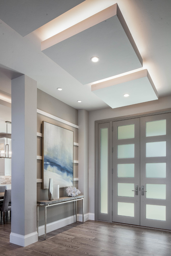 Example of a large trendy porcelain tile and gray floor entryway design in Miami with gray walls and a glass front door