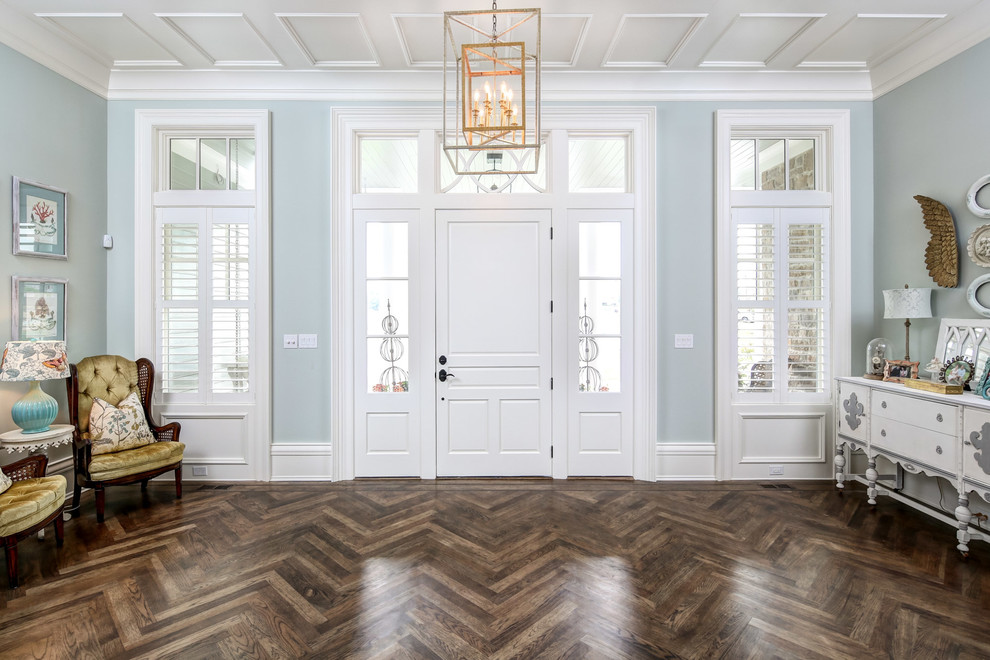 Example of a classic dark wood floor and brown floor entryway design in Louisville with blue walls and a white front door