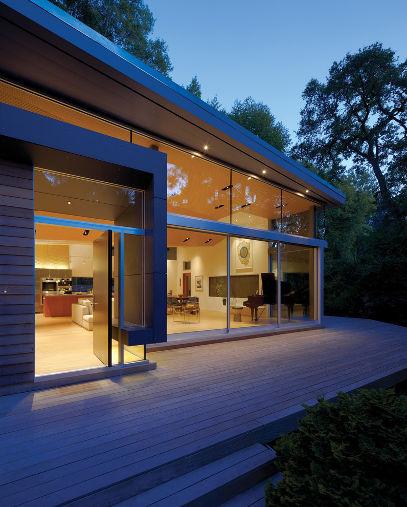 Example of a mid-sized minimalist light wood floor pivot front door design in San Francisco with a dark wood front door and white walls
