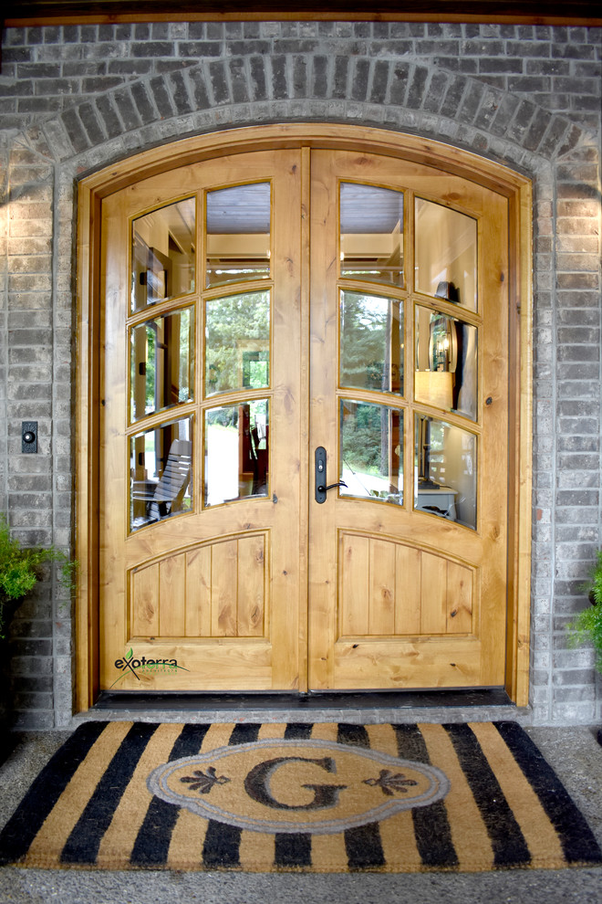 ナッシュビルにある高級な広いトラディショナルスタイルのおしゃれな玄関ドア (マルチカラーの壁、コンクリートの床、木目調のドア、グレーの床) の写真