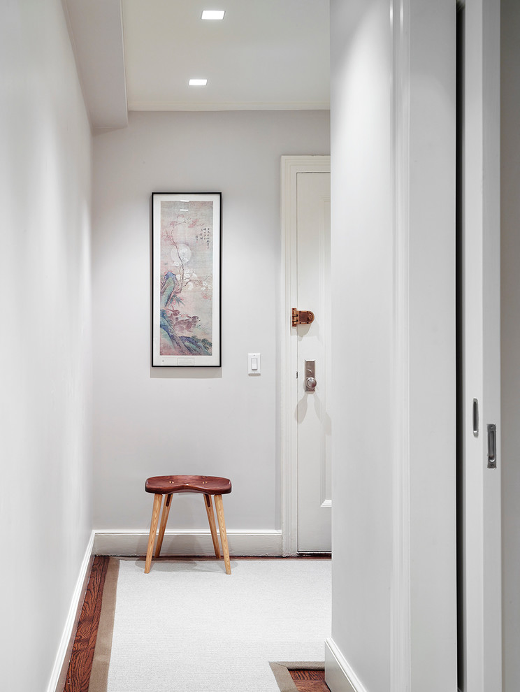 Exemple d'une petite porte d'entrée chic avec un mur blanc, un sol en bois brun, une porte simple et une porte blanche.