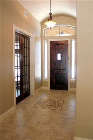 Foto di una porta d'ingresso tradizionale di medie dimensioni con pareti beige, pavimento in travertino, una porta singola e una porta in legno scuro