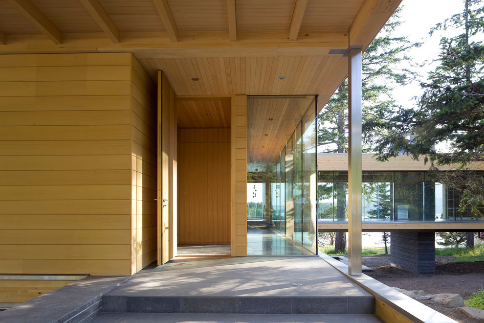 Photo of a modern entrance in Vancouver with a single front door and a medium wood front door.