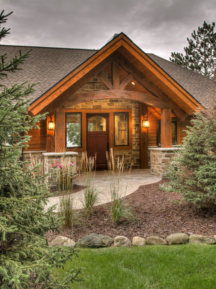 This is an example of a rustic front door in Minneapolis with brown walls, a single front door and a medium wood front door.