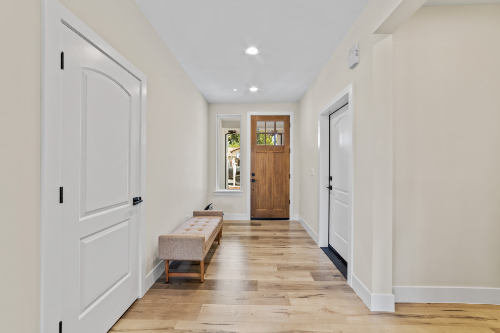 Esempio di una porta d'ingresso classica di medie dimensioni con pareti beige, pavimento in laminato, una porta singola, una porta in legno bruno e pavimento beige
