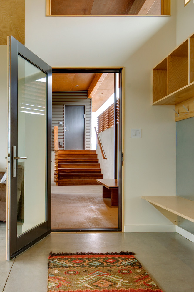 Moderne Haustür mit weißer Wandfarbe, Betonboden, Einzeltür und Haustür aus Glas in Seattle