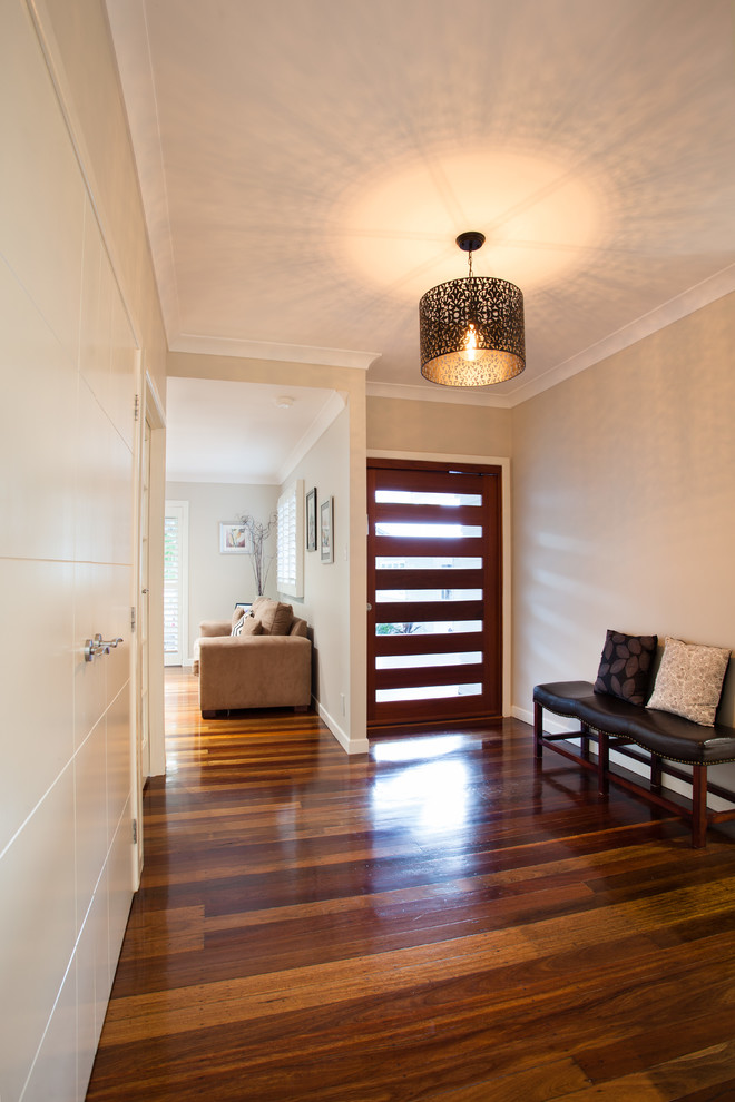 Ispirazione per un piccolo ingresso classico con pareti bianche, pavimento in legno massello medio, una porta singola e una porta in legno bruno