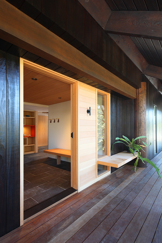 Idée de décoration pour une grande porte d'entrée design avec un sol en carrelage de porcelaine, une porte simple et un sol gris.