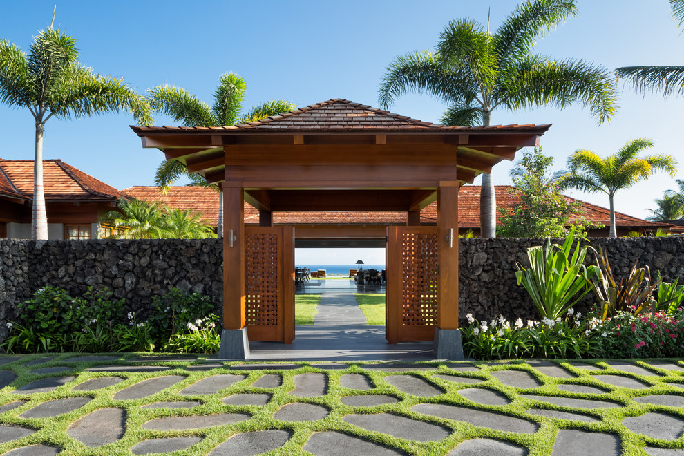 ハワイにあるラグジュアリーな巨大なトロピカルスタイルのおしゃれな玄関の写真