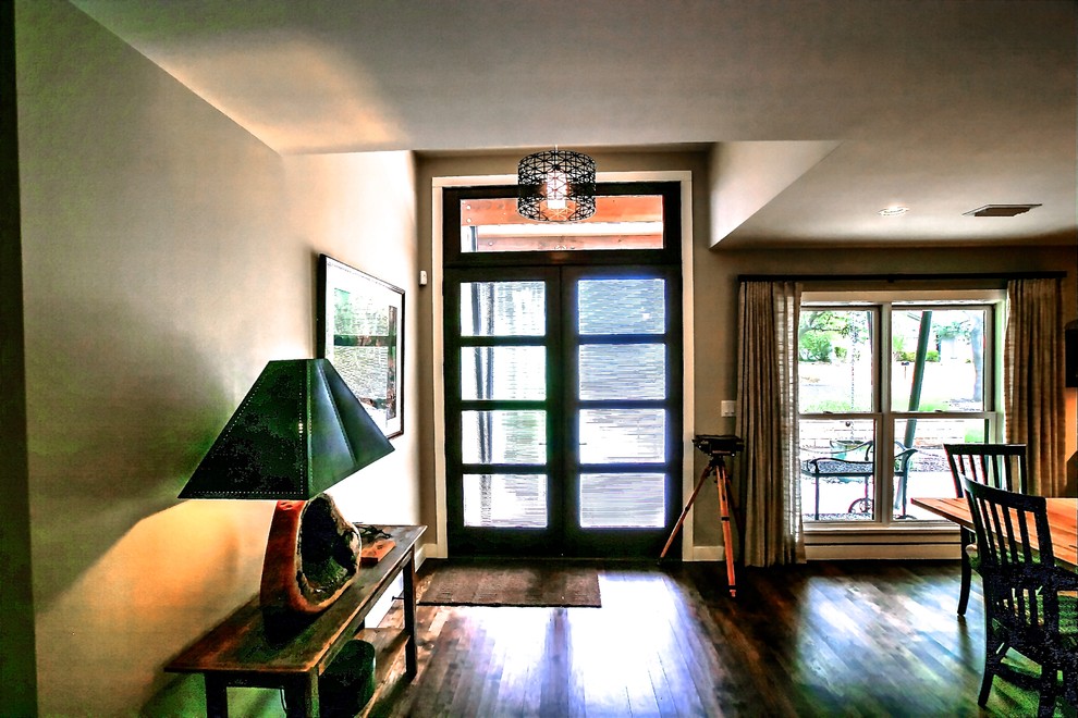 На фото: большая входная дверь в стиле модернизм с бежевыми стенами, паркетным полом среднего тона, двустворчатой входной дверью и входной дверью из темного дерева