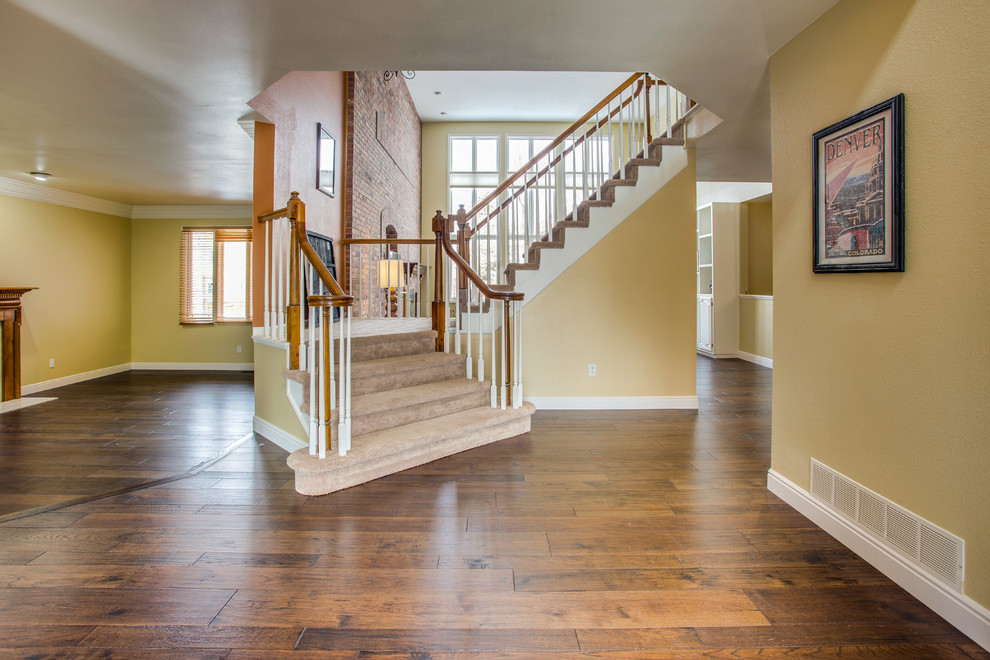 Inspiration for a mid-sized transitional medium tone wood floor and brown floor entry hall remodel in Denver with yellow walls