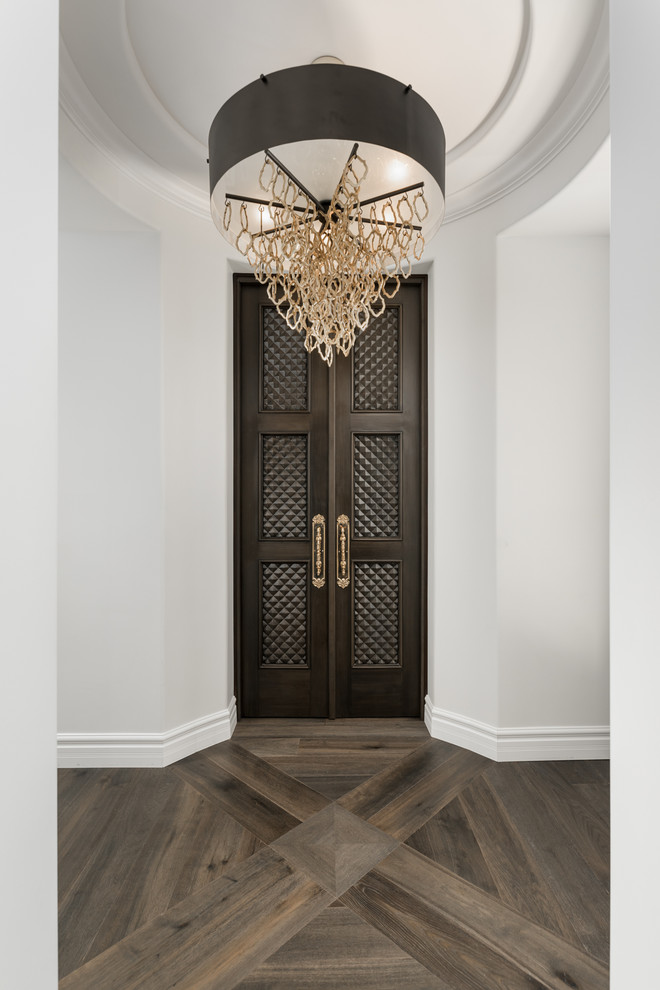 フェニックスにあるラグジュアリーな巨大なシャビーシック調のおしゃれな玄関ロビー (白い壁、濃色無垢フローリング、濃色木目調のドア、茶色い床) の写真