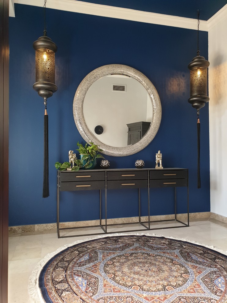 他の地域にあるお手頃価格の広いエクレクティックスタイルのおしゃれな玄関ホール (青い壁、セラミックタイルの床、黒いドア) の写真