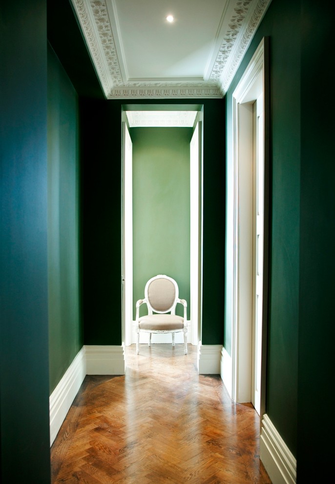 Imagen de hall tradicional de tamaño medio con paredes verdes, suelo de madera en tonos medios y suelo marrón