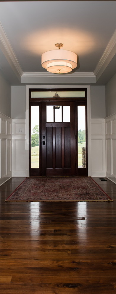 Immagine di un grande ingresso stile americano con pareti grigie, parquet scuro, una porta singola e una porta in legno scuro